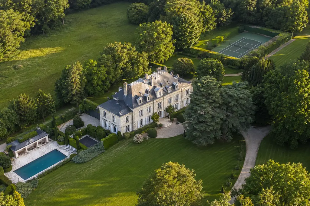 Vue aérienne d’une propriété de caractère avec parc paysager, piscine et court de tennis